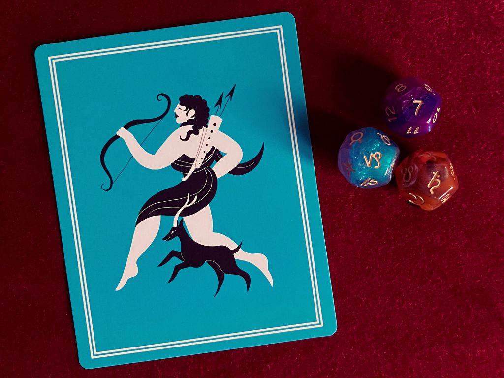 Artemis oracle card and astrology dice used for a personal reflection on relationship narratives and truth